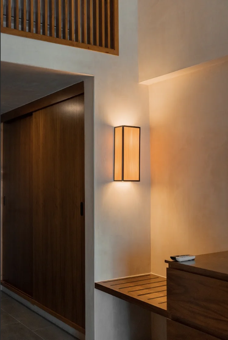 Pared interior de habitación en Hive Cancún con lámpara decorativa e iluminación cálida
