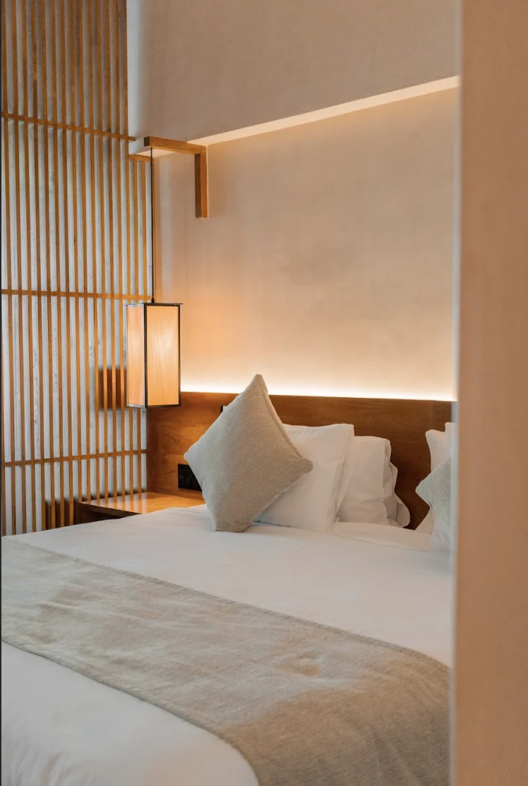 Cama perfectamente ordenada en habitación de Hive Cancún