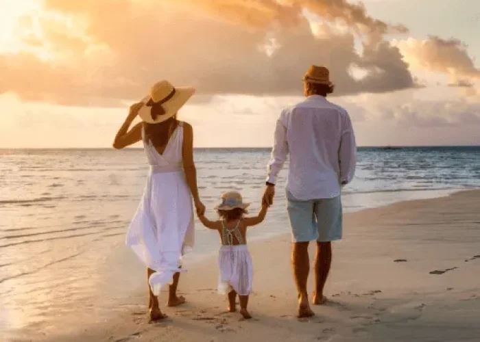 Familia caminando junta por la playa, disfrutando de un día soleado y creando recuerdos especiales en un entorno natural y relajante