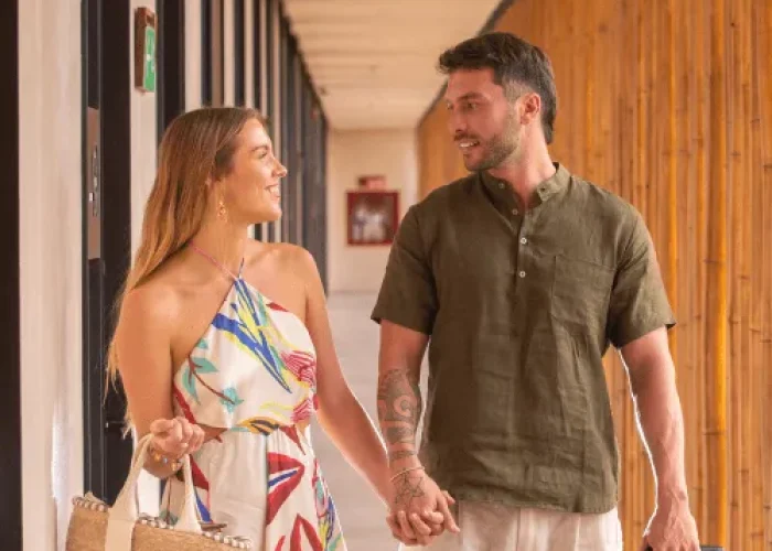 Pareja caminando junta, disfrutando de un paseo al aire libre con sonrisas y complicidad.